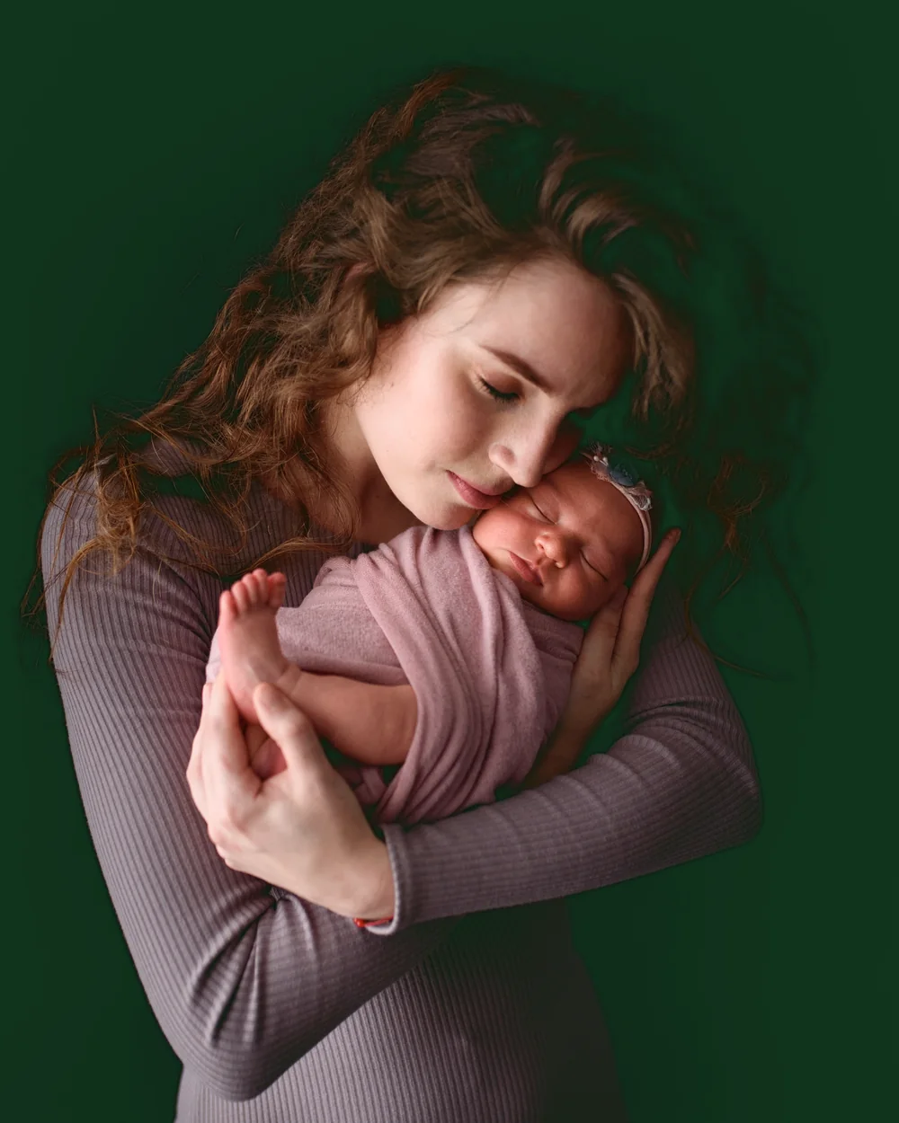 Una mamma tiene in braccio la sua bambina appena nata, guancia contro guancia